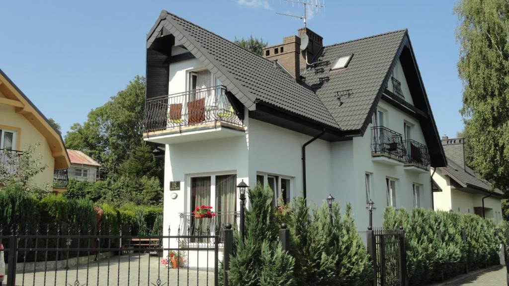 une maison blanche avec un toit noir dans l'établissement Heweliusz, à Ustka