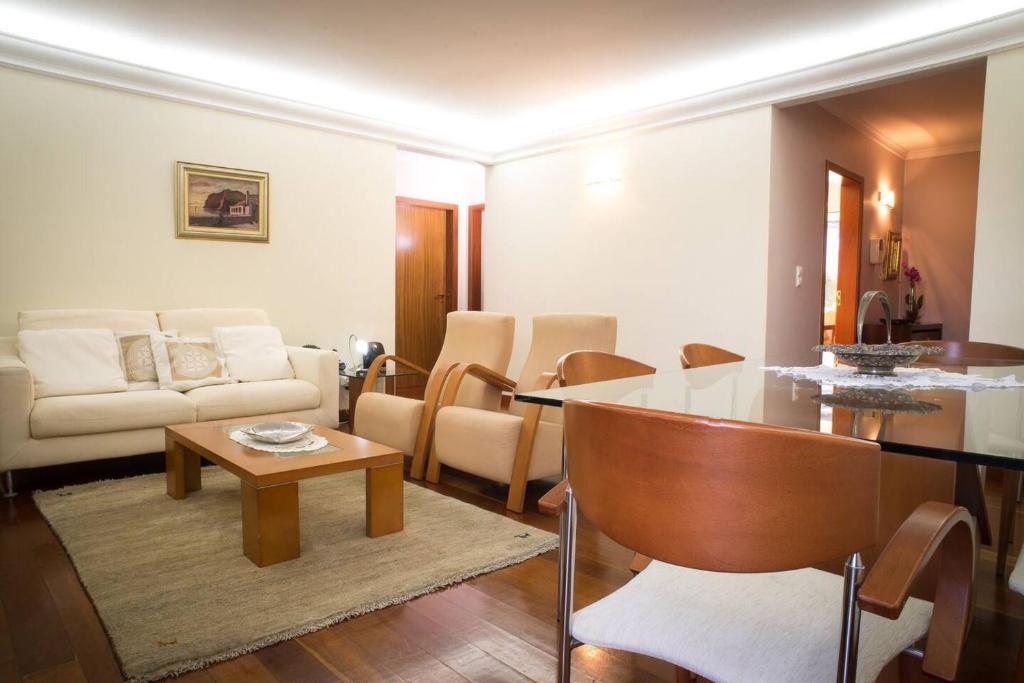 ein Wohnzimmer mit einem Tisch und einem Sofa in der Unterkunft 2 bedrooms appartement with wifi at Camara De Lobos 4 km away from the beach in Funchal
