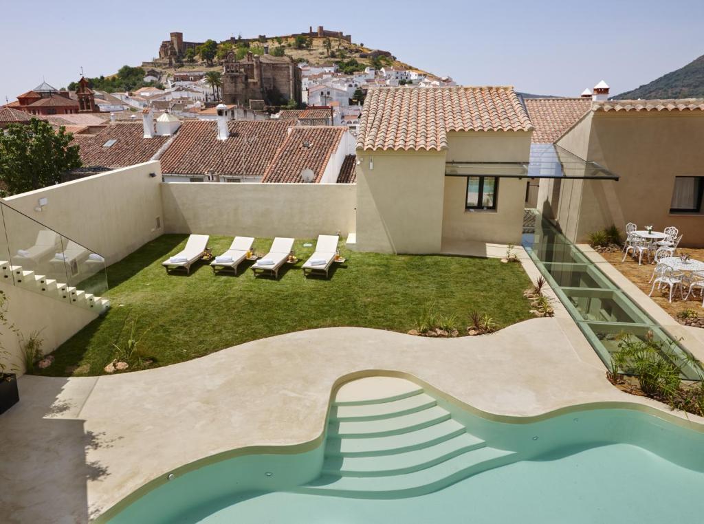 a patio area with chairs, tables, and lawn chairs at Hotel Galería Essentia in Aracena