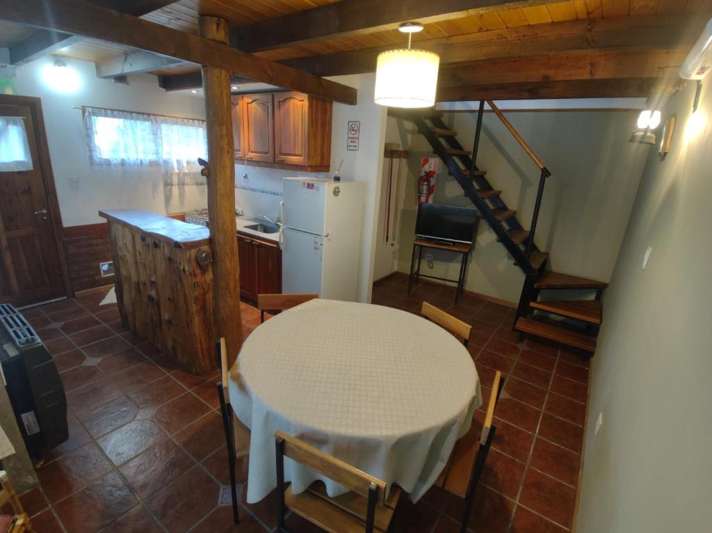 a kitchen and dining room with a table and a staircase at Cabañas Don Carlos in El Hoyo