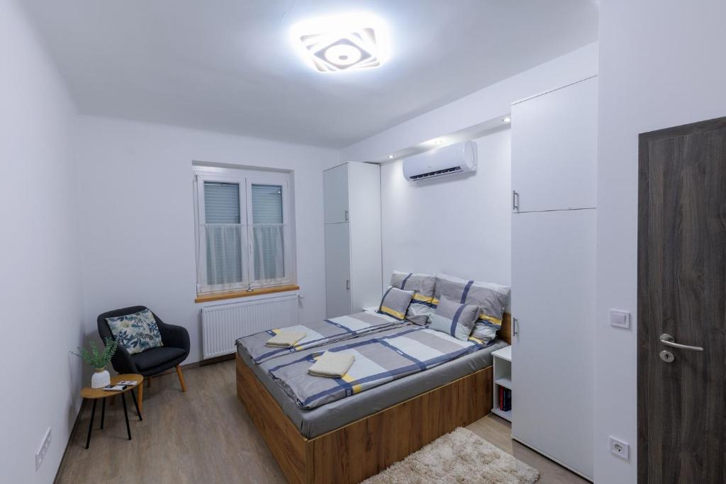 ein Schlafzimmer mit einem Bett und einem Stuhl darin in der Unterkunft Gyöngy Apartman in Pécs