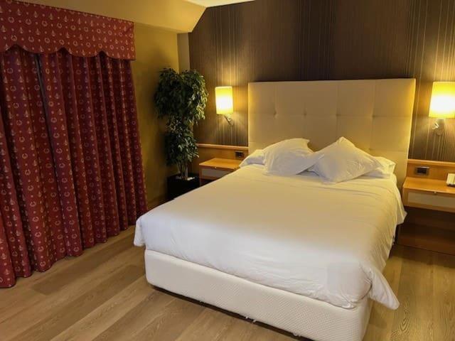 Un dormitorio con una gran cama blanca y una ventana en Coto Real, en Rábade