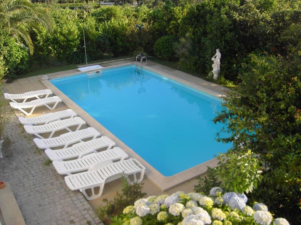 an overhead view of a swimming pool with white lounge chairs at 2 bedrooms house with shared pool enclosed garden and wifi at Ponte de Lima in Ponte de Lima
