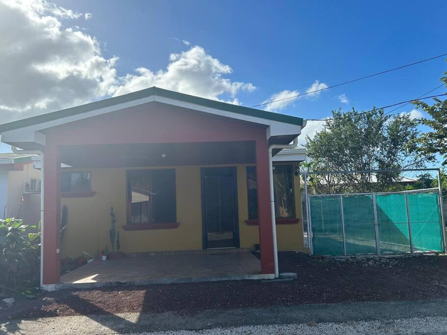une petite maison jaune et blanche avec une clôture dans l'établissement Casa Sendero, à Liberia