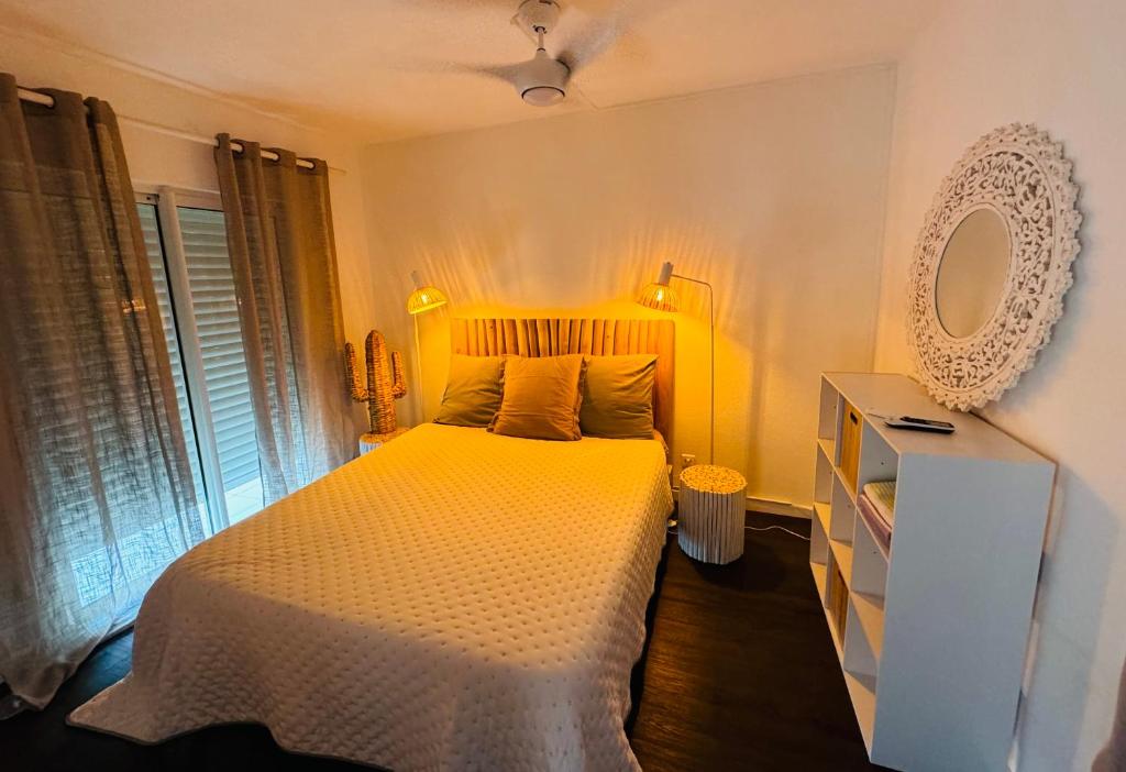 1 dormitorio con cama blanca y espejo en Colors by MG2 en Saint Martin