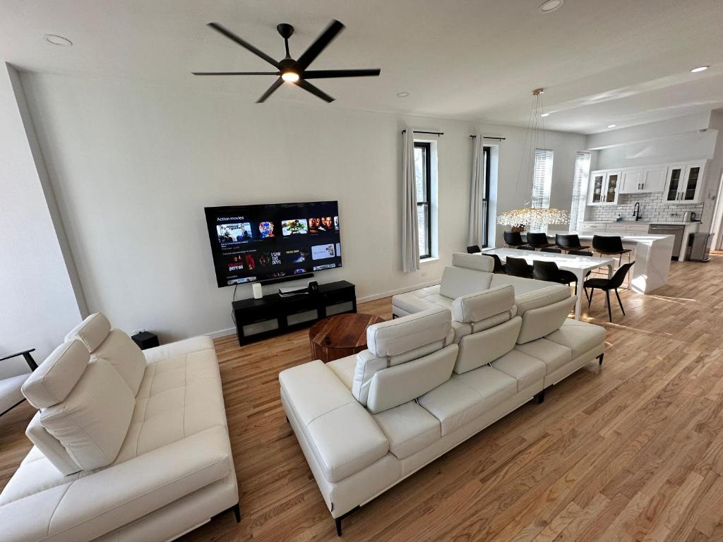 a living room with white couches and a dining room at Luxe Spacious SFH in Bucktown with Secure Parking in Chicago
