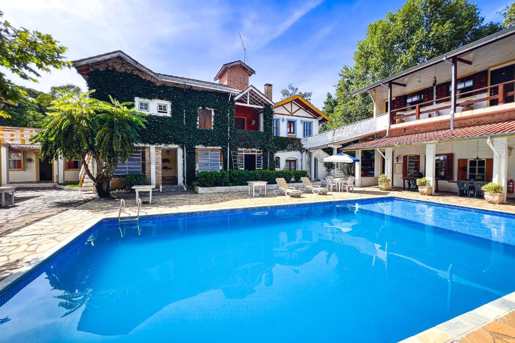 uma piscina em frente a uma casa em VELINN Pousada Cesar em Santo Antônio do Pinhal