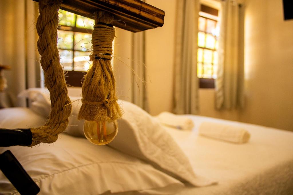 ein Schlafzimmer mit einem Bett, über dem ein Seil hängt in der Unterkunft Encanto Paraty Beach in Paraty