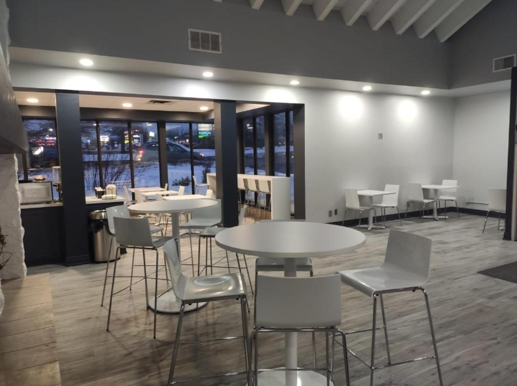 a dining room with tables and white chairs at Travelodge by Wyndham Barrie in Barrie