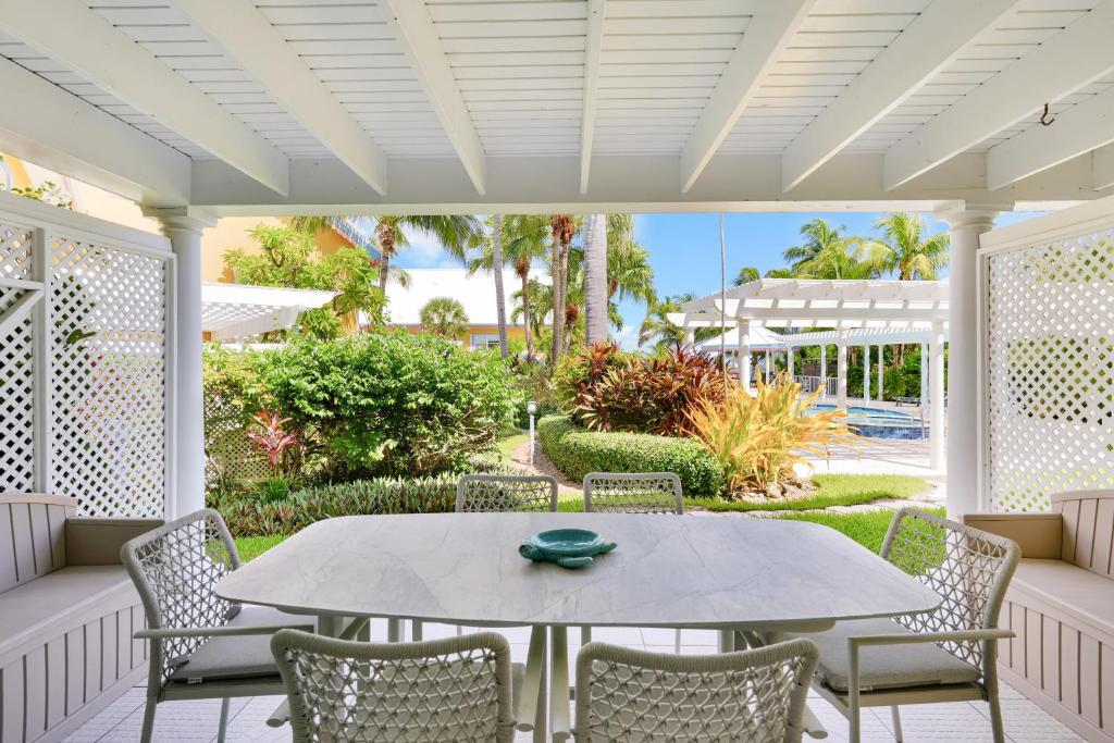 a patio with a table and chairs and a yard at Coconut Bay Villas #113 in George Town