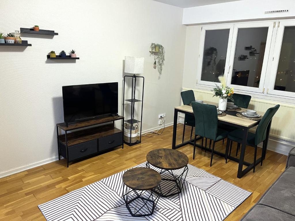 een woonkamer met een tafel en een televisie bij Charmant Appartement à Metz in Metz