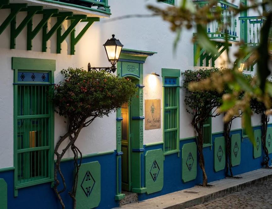 un edificio con puertas y árboles verdes y azules en Casa Cedrela Hotel Boutique, en Jericó