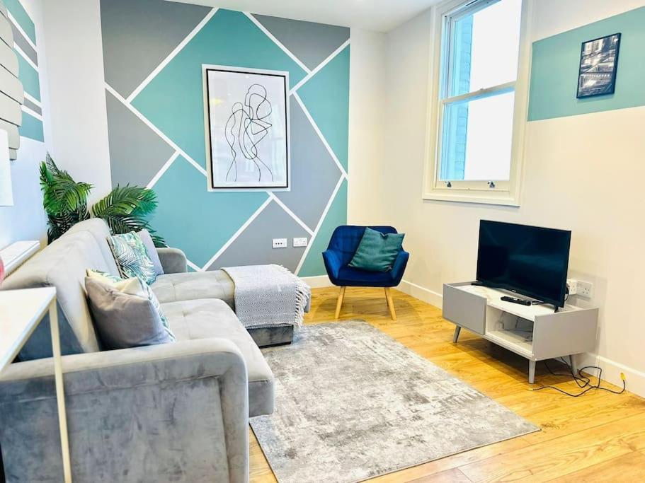 a living room with a couch and a tv at SeaView Apartment with Roof Terrace and Pool Table in Kent