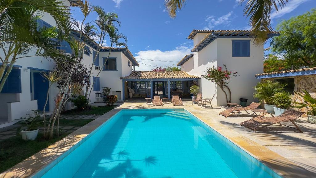 a swimming pool in front of a house at Pousada Vila Capri in Búzios