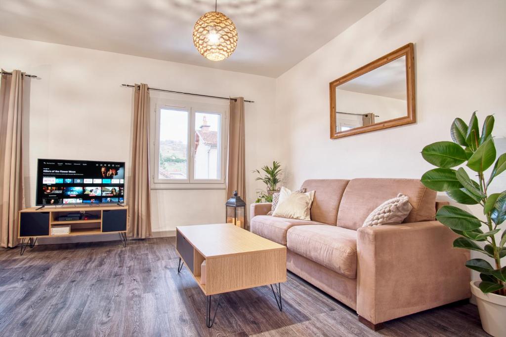 un salon avec un canapé et une télévision dans l'établissement Bel appartement tout confort en Aveyron, à Firmi