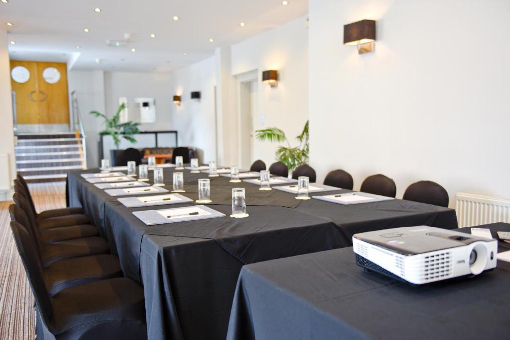 a meeting room with long tables and chairs and a projector at The Riviera Hotel & Apartments - Alum Chine in Bournemouth