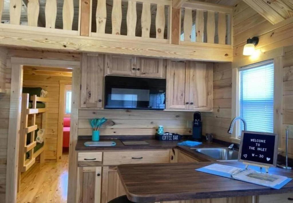 eine Küche mit Holzschränken und einer Arbeitsplatte in der Unterkunft Unique Cabin Near Surf City with Loft and Parking in Surf City