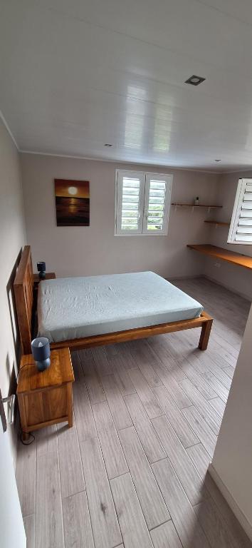 a bedroom with a bed in a room with windows at LOCATION LA MONTAGNE MARTINIQUE in Le Vauclin