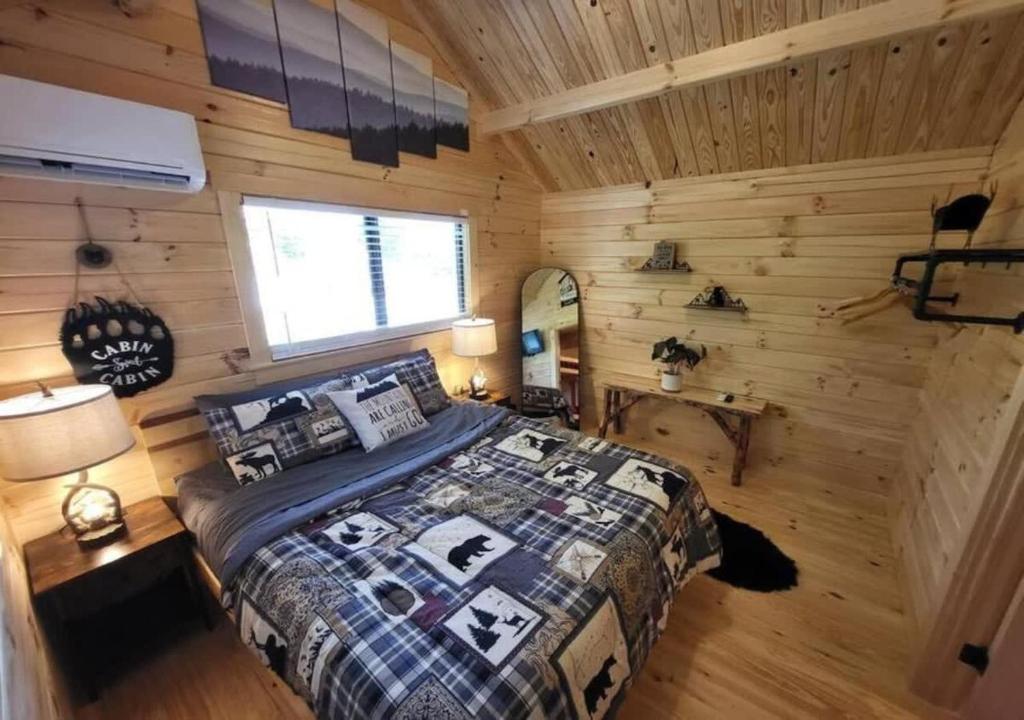 a bedroom with a bed in a log cabin at Picturesque Family Cabin with Loft in Tennessee in Sevierville