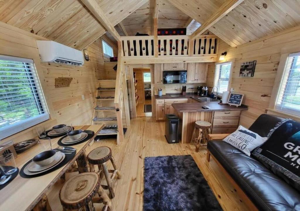 a living room and kitchen in a log cabin at Picturesque Family Cabin with Loft in Tennessee in Sevierville