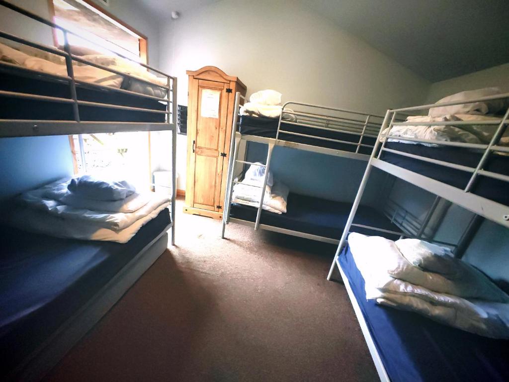 a room with three bunk beds and a window at Private Room at Torrent Walk Bunkhouse in Snowdonia in Dolgellau