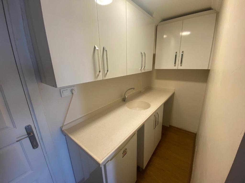 a bathroom with a sink and white cabinets at Eylül suit otel in Yıldırım