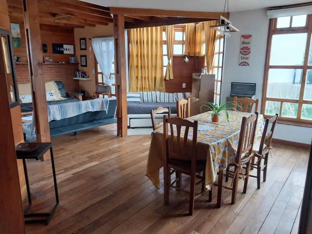 a dining room with a table and chairs and a bedroom at Horizonte Fueguino II in Ushuaia