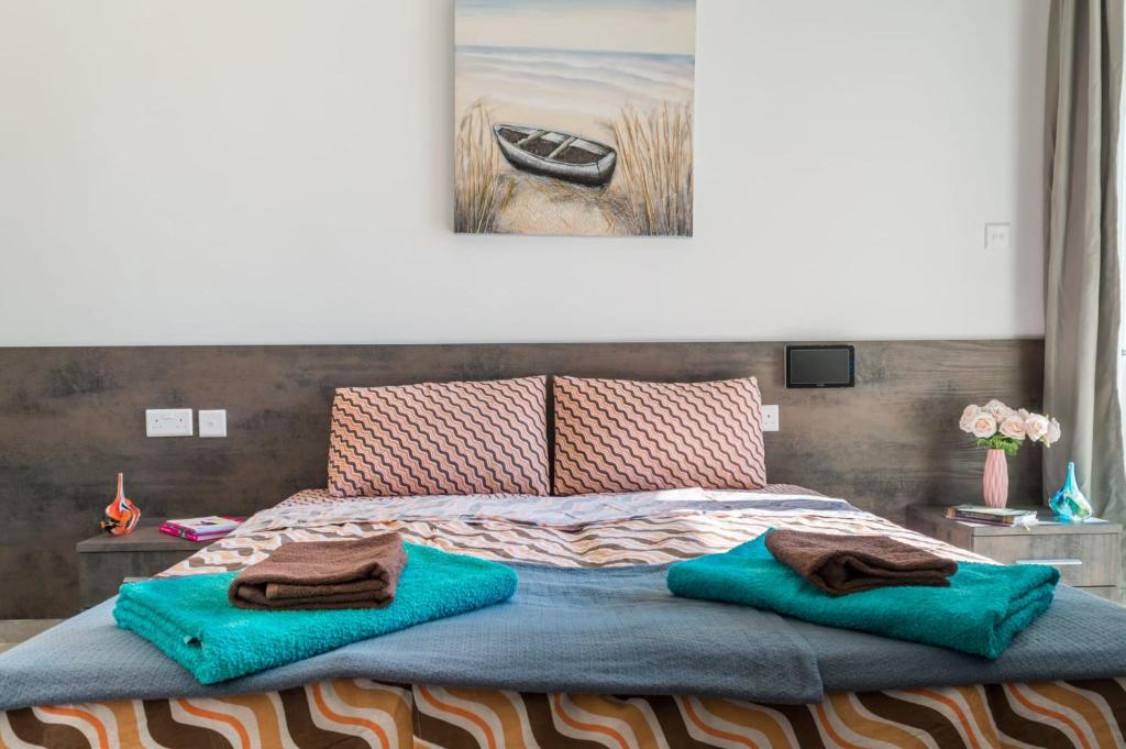a bedroom with a bed with two towels on it at Spacious Brand New Apartment 3 Bdr 2Bth Bugibba HC12 in St. Paul's Bay