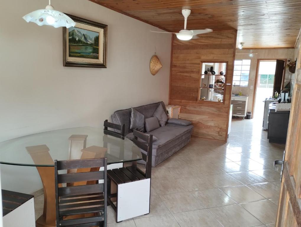uma sala de estar com uma mesa de vidro e um sofá em Lugarzinho Aconchegante - Q1 em Curitiba