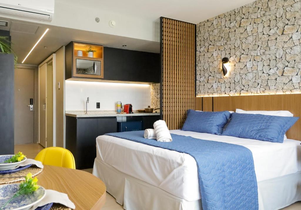 1 Schlafzimmer mit einem großen Bett und einer Küche in der Unterkunft Loft de Luxo no Bairro mais nobre de Goiânia in Goiânia