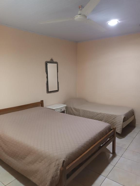 a bedroom with two beds and a mirror on the wall at RESIDENCIAL SILVIA in Puerto Iguazú