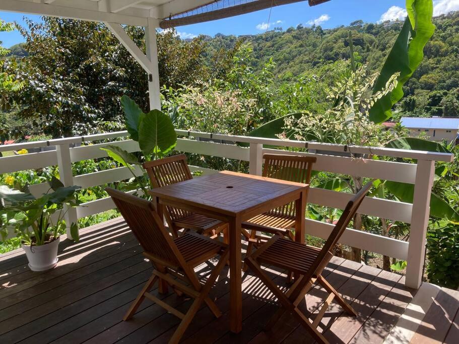 un tavolo in legno e 2 sedie su una terrazza di Studio Nature a la Montagne a Le Vauclin