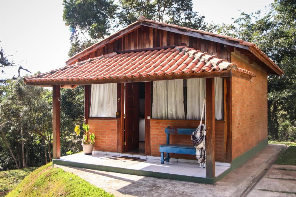 un pequeño cobertizo con un banco azul en un patio en Pousada Estalagem Mirante, en Aiuruoca