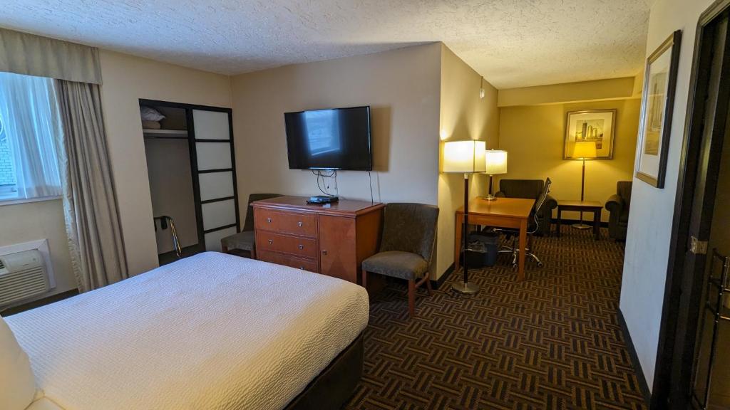 a hotel room with a bed and a flat screen tv at Wyndham Garden Medicine Hat Conference Center in Medicine Hat