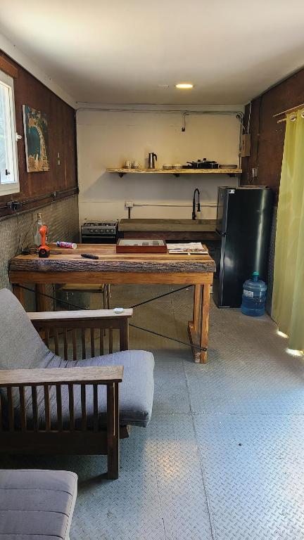 Cozy Surf Studio in Gigante في تولا: مطبخ مع طاولة خشبية وثلاجة