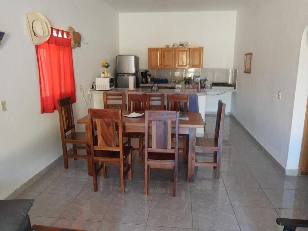 een keuken en eetkamer met een tafel en stoelen bij Hotel y Bungalows Bugambilias in San Patricio Melaque