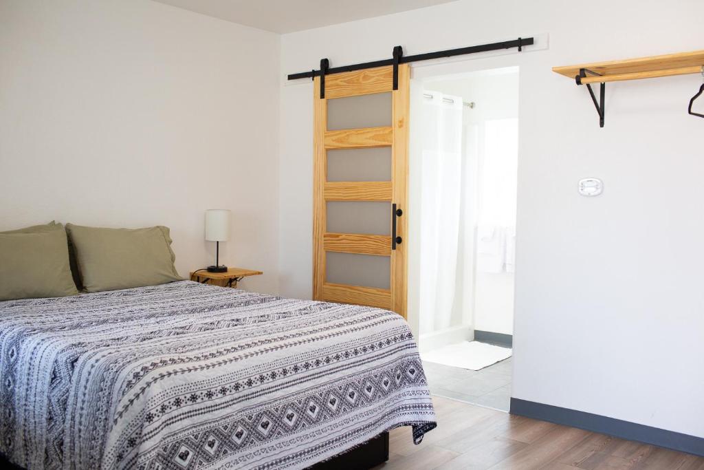 - une chambre avec un lit et une porte ouverte dans l'établissement The Sage Motel, à Saratoga