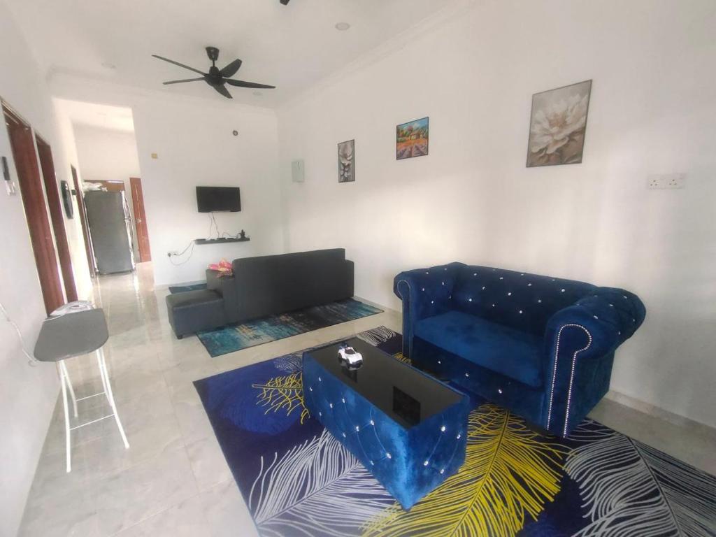 ein Wohnzimmer mit einem blauen Sofa und einem Tisch in der Unterkunft Mie Homestay in Pasir Mas