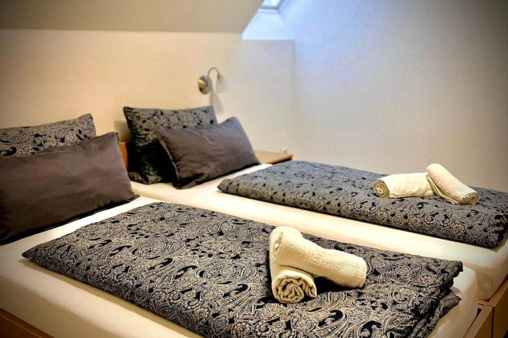 Dos camas en una habitación con toallas. en Pension Maria, en Rochlitz