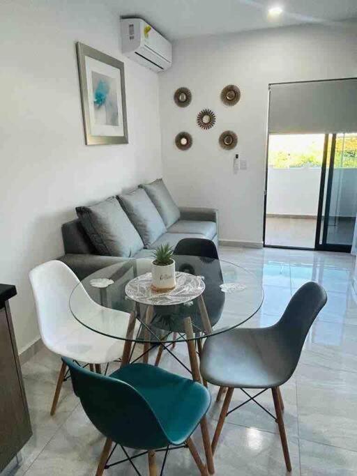 a living room with a glass table and chairs at Loft Marina Cerritos in Mazatlán