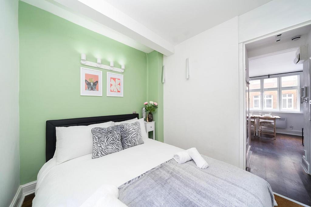 a bedroom with a bed and a green wall at Soho Apartments F2 in London