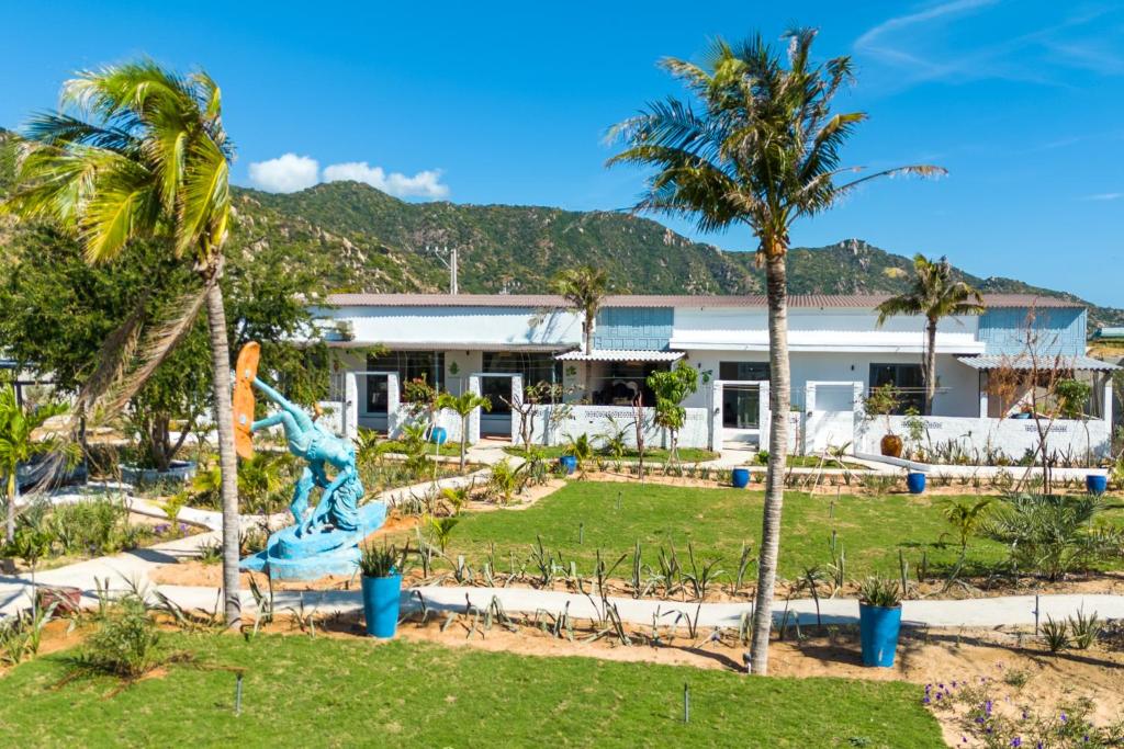 een resort met een standbeeld en palmbomen bij Chilli Fields in Phan Rang