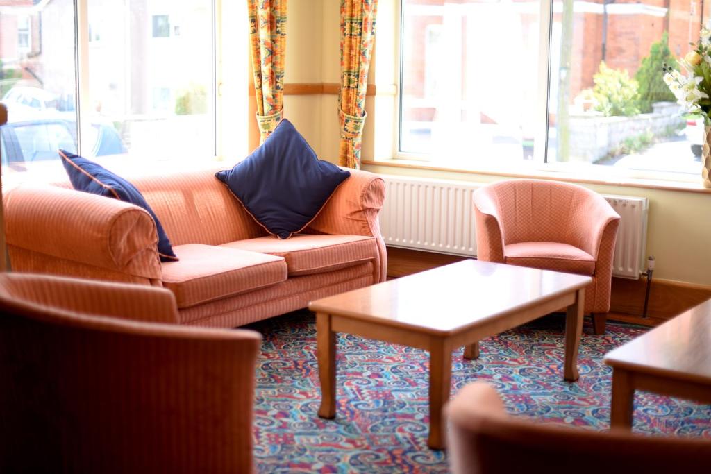 a living room with a couch and two chairs at The Riviera Hotel & Apartments - Alum Chine in Bournemouth