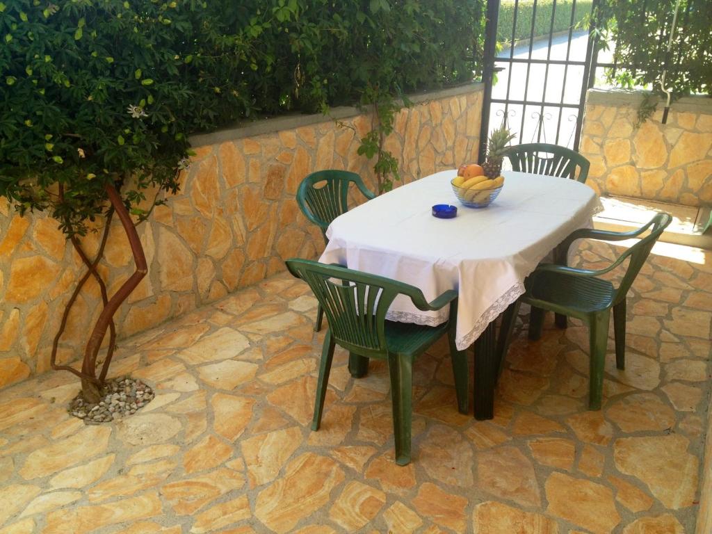 - une table avec des chaises et une corbeille de fruits dans l'établissement Apartment Nela, à Funtana