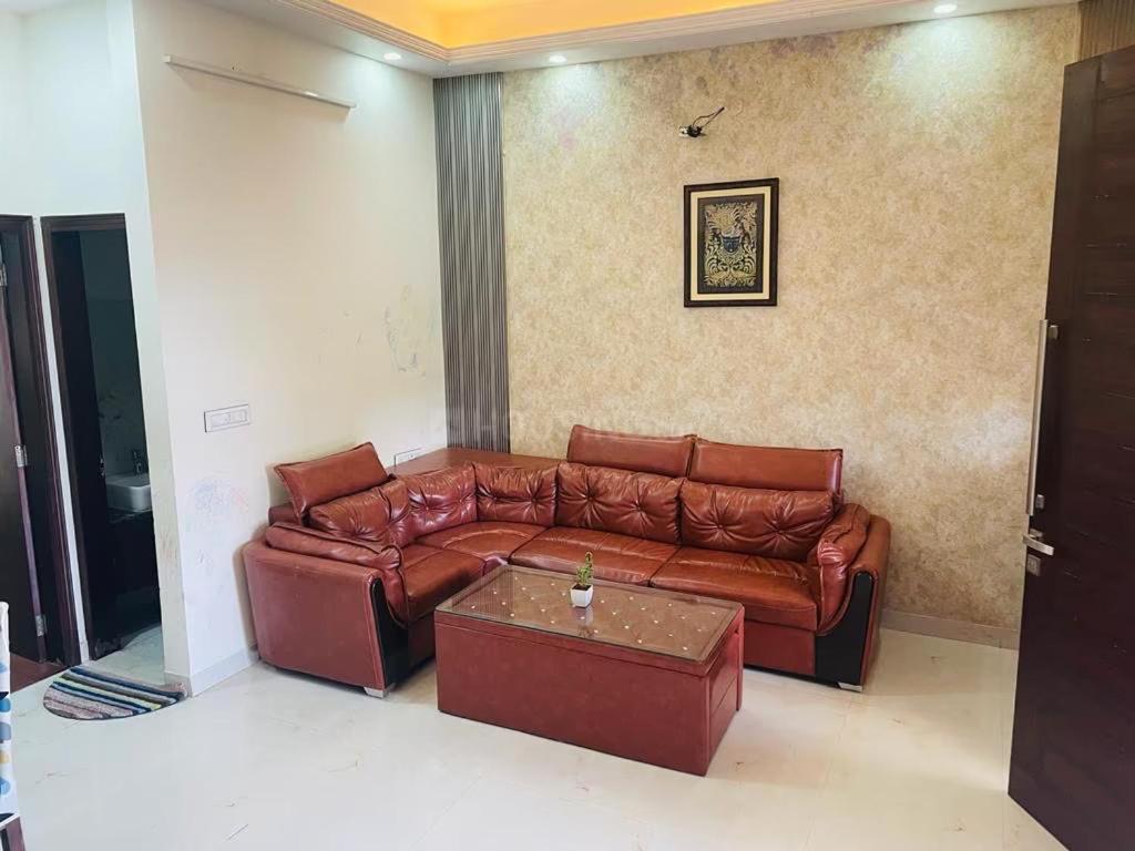 a living room with a brown leather couch at Naini House in Nainital