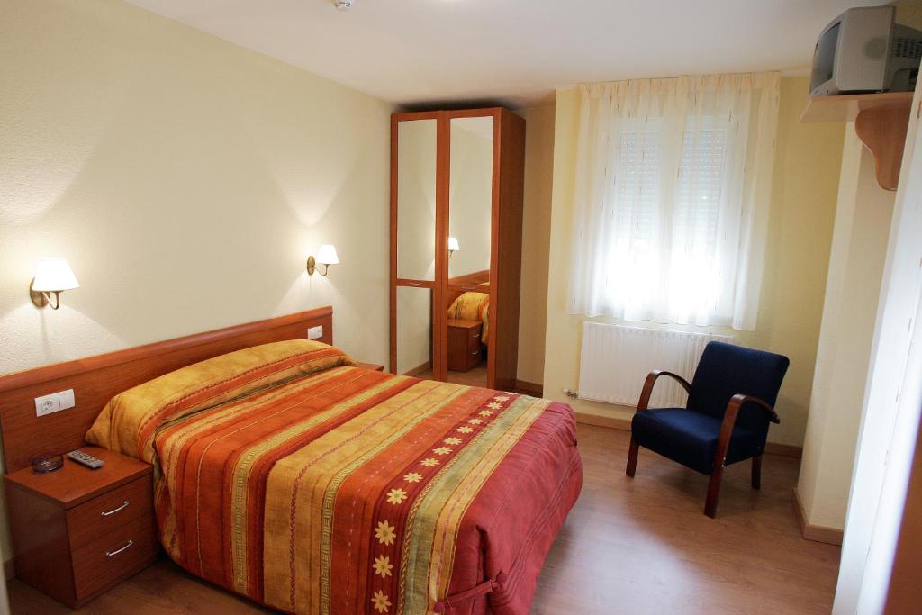 een hotelkamer met een bed en een stoel bij Hostal Hispanico II in Salamanca