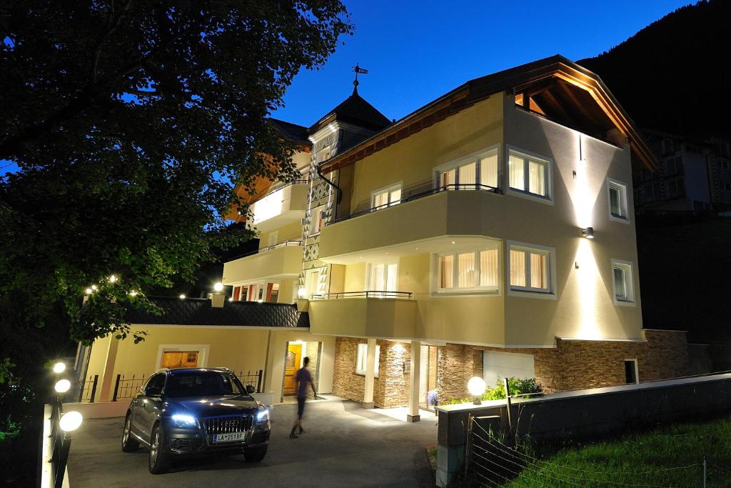 a car parked in front of a building at night at Jungmann Apartments in Ischgl