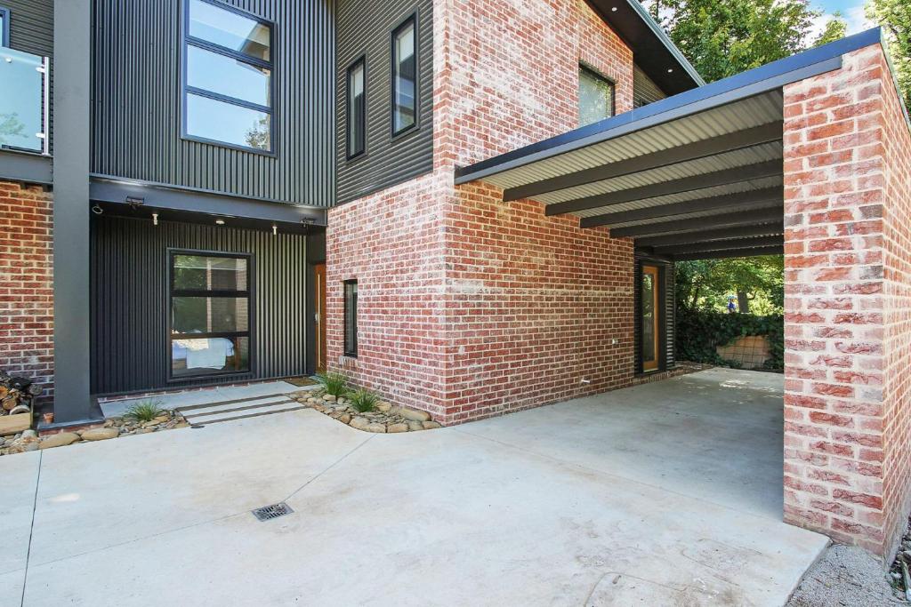 un edificio de ladrillo con garaje abierto en Delany by the Park - House, en Bright