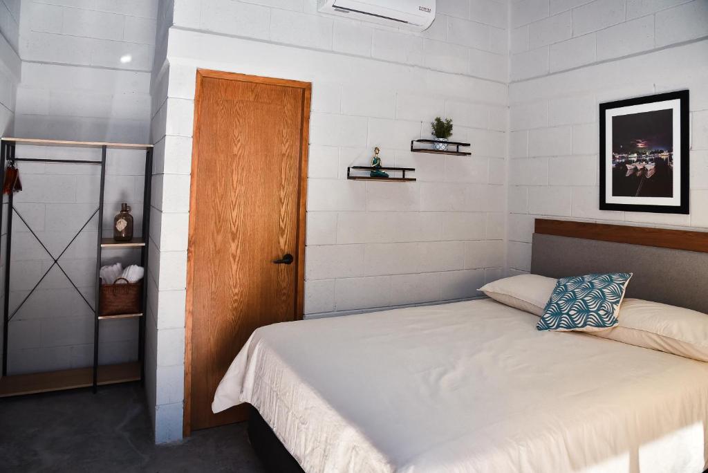 - une chambre avec un lit et une porte en bois dans l'établissement Sealion Dive Center, à Topolobampo