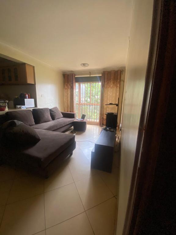 a living room with a couch and a table at Pal central nest in Kampala